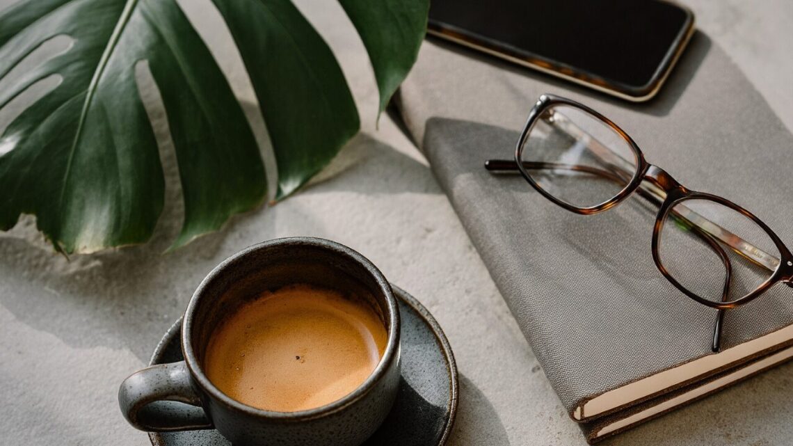 Eyeglasses resting on an open notebook in soft natural light.