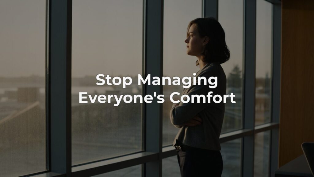 A woman pausing at a window in soft morning light, embodying leadership clarity through quiet reflection.