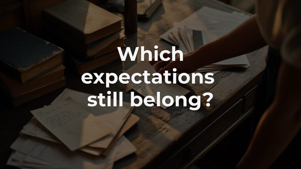 A hand examining scattered notes on a wooden desk, representing leadership expectations accumulated over time.