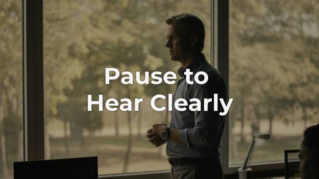 A thoughtful leader standing by a window in soft morning light, hands clasped in quiet reflection, embodying effective listening and calm presence